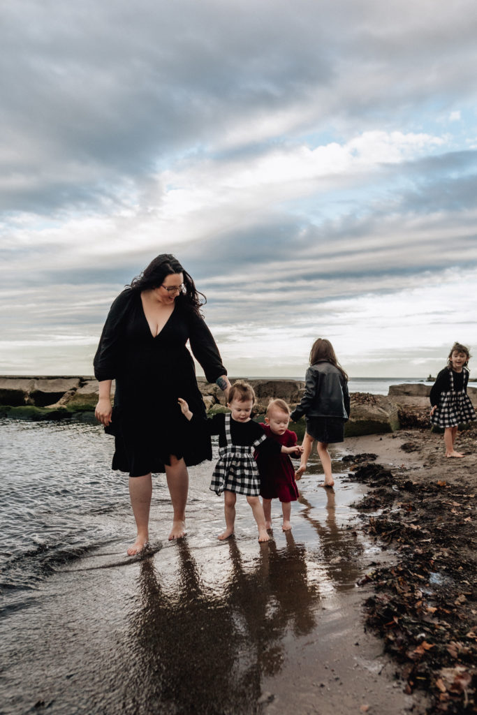 mom and her four daughters dip their toes in the lapping waves of lake erie
