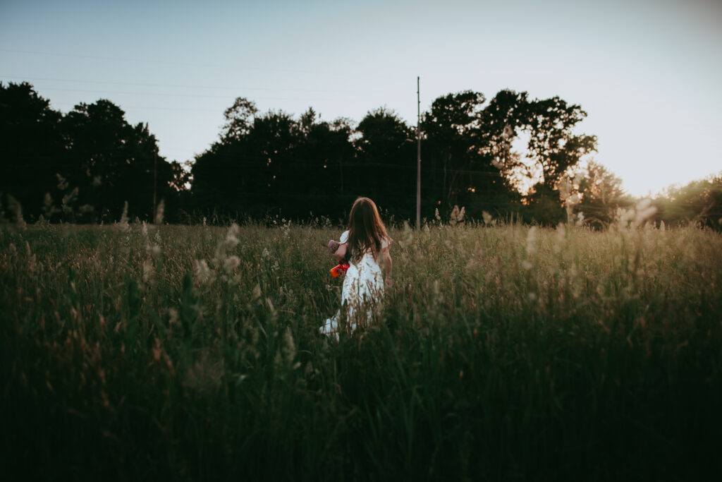 little girl running into field of grass
