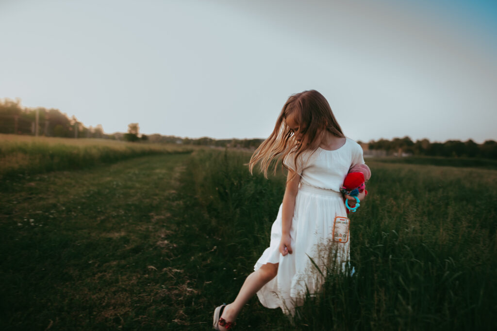 little girl holding her dress while walking