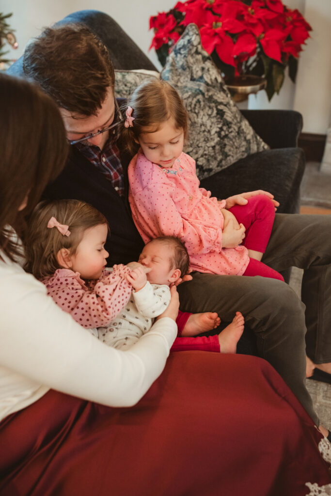 whole family snuggles new baby on the couch