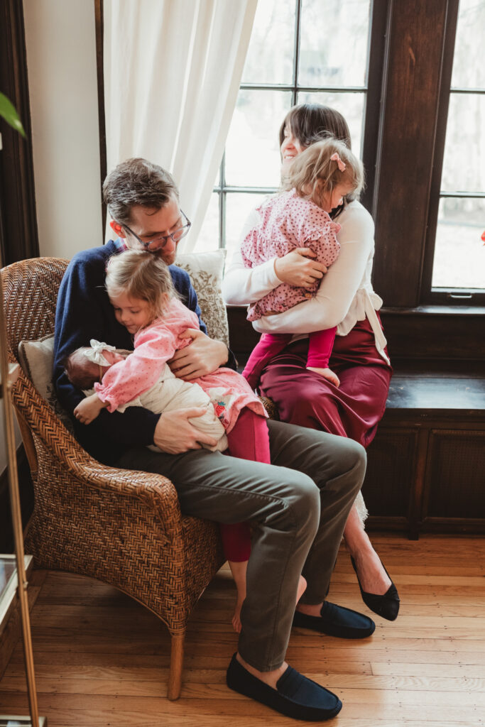 mom and dad each snuggle and hug their daughters