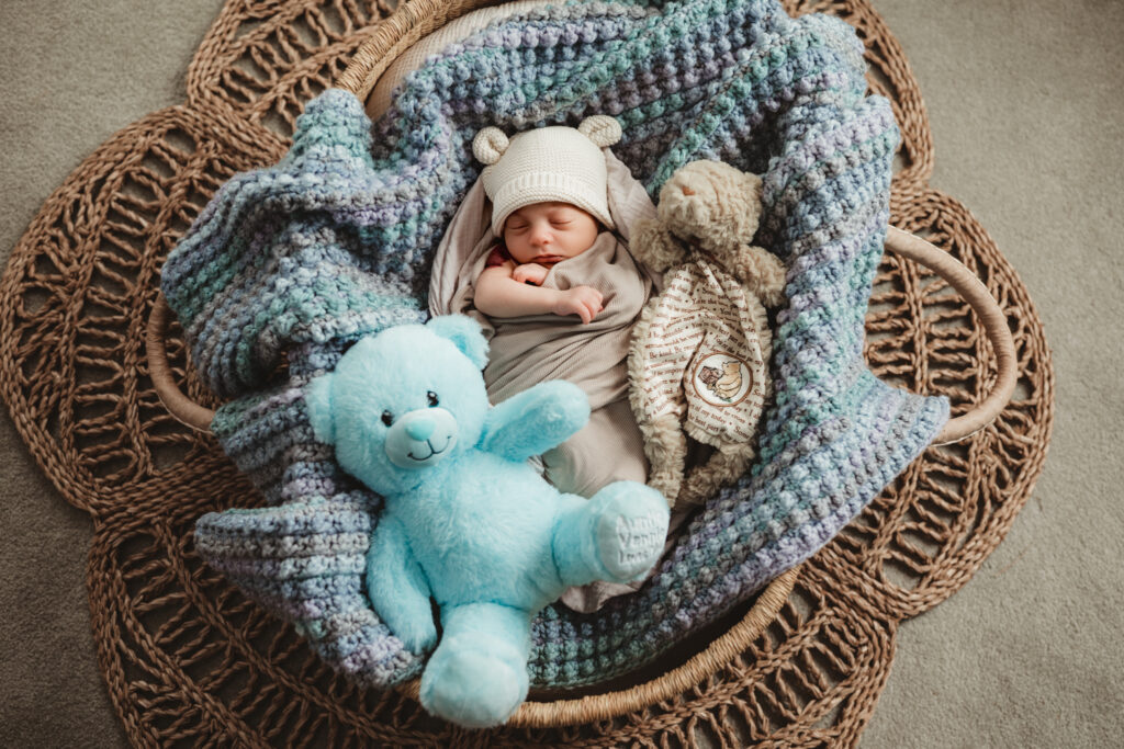 baby snuggled with his blue bear and winnie the pooh silkie.