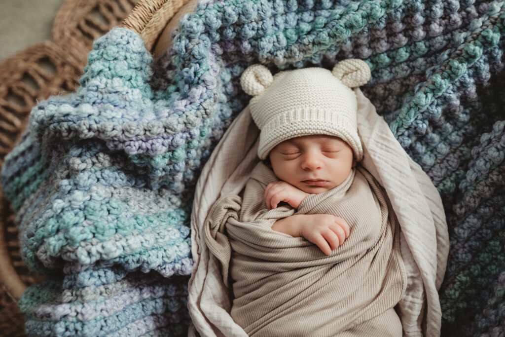 close up of swaddled baby in the Moses basket