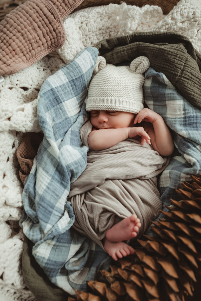 baby stretching in the Moses basket with his feet and hands out.