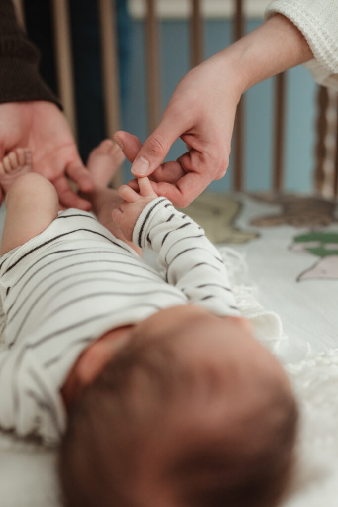 close up of mom holding baby's hand
