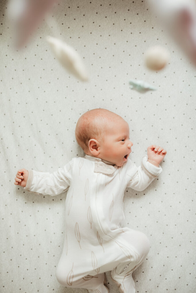 baby under his mobile in his crib