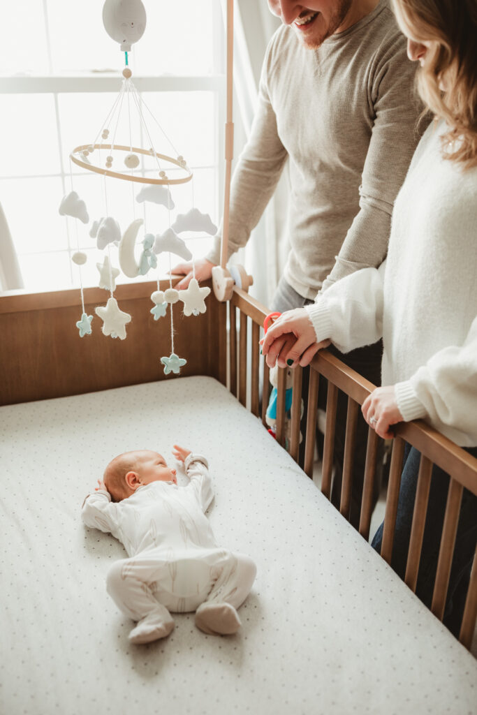 parents looking into crib at newborn