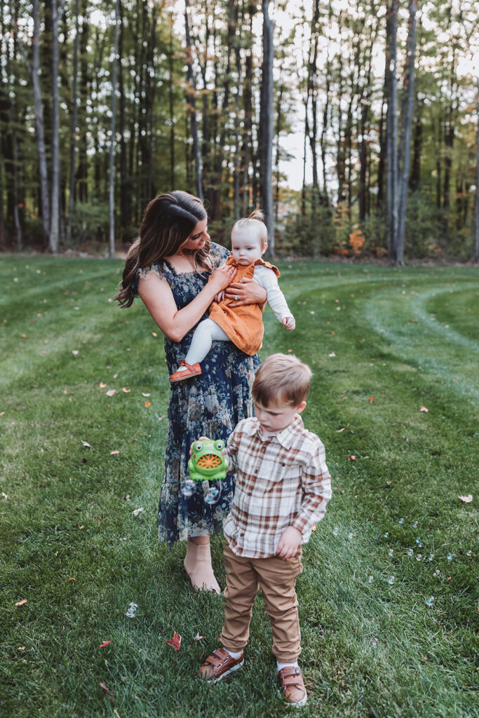 end of the session, mom cuddles daughter while son plays with bubble machine
