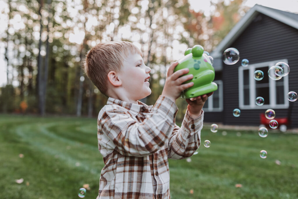 little boy plays with bubble machine