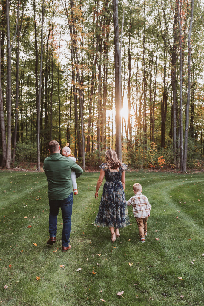 family walking away from camera into the sun