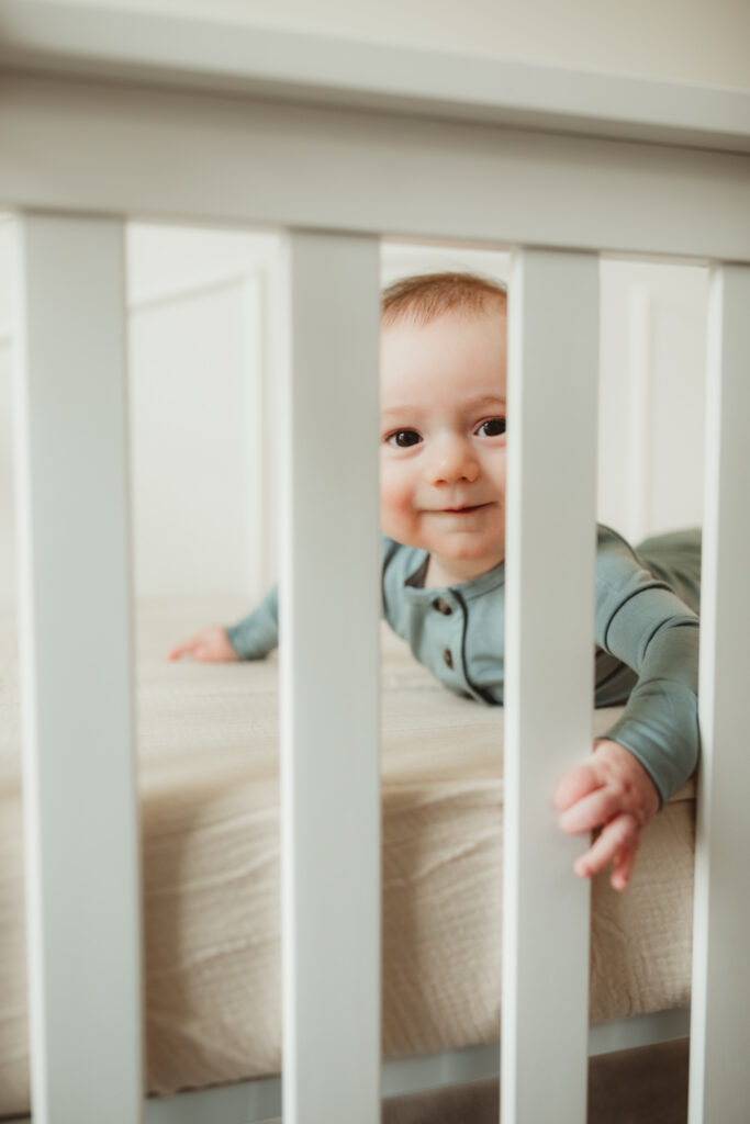baby peeks out between crib slats