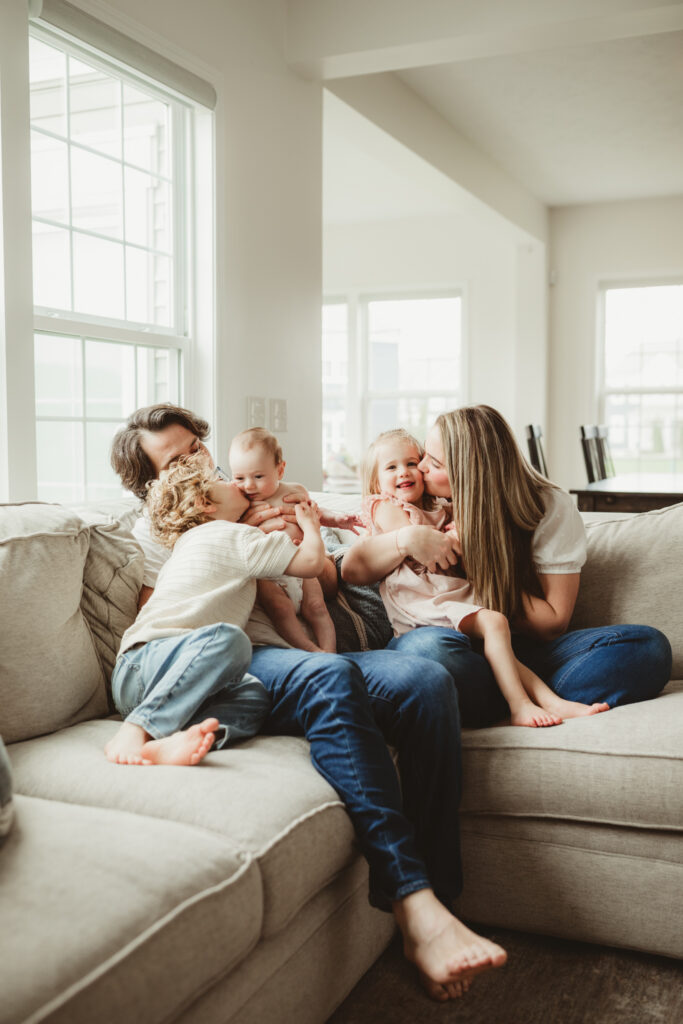 family cuddles on the couch, hugs and kisses