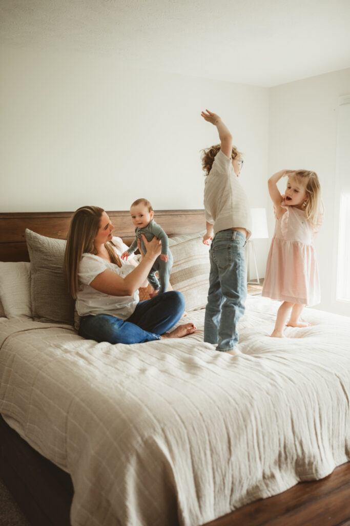mom on bed with kids while they dance and bounce