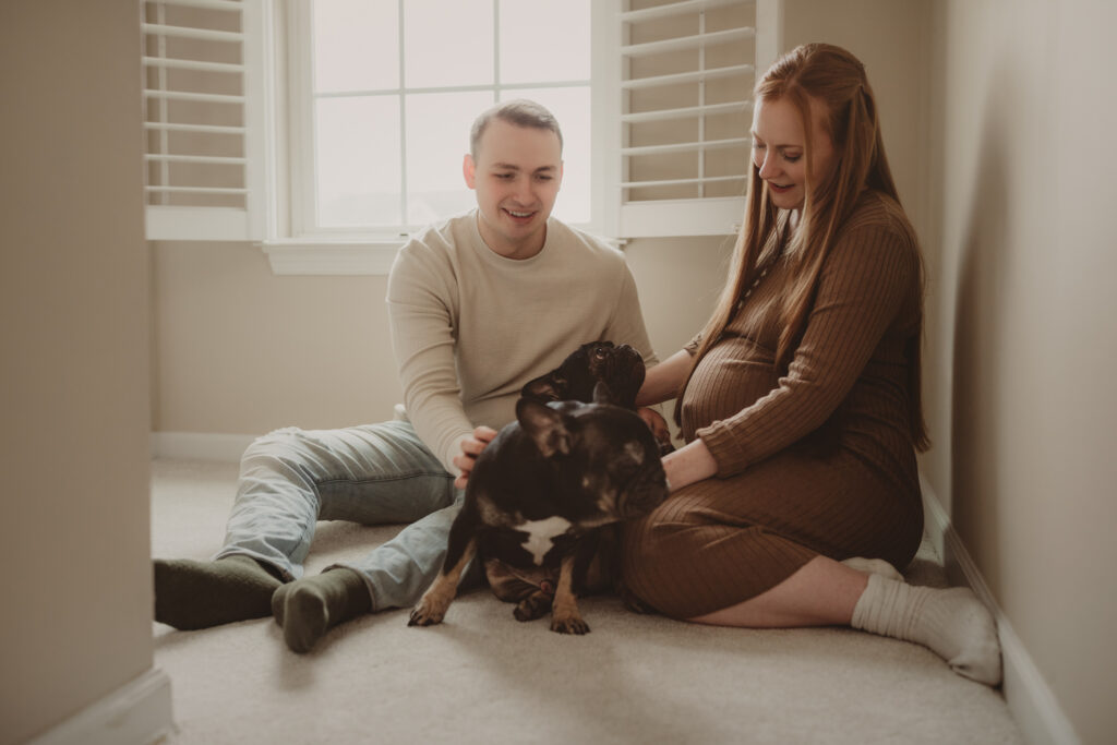 couple sitting on the floor with their two french bulldogs