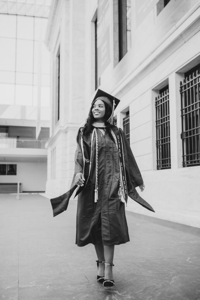 black and white of grad walking towards camera looking off camera